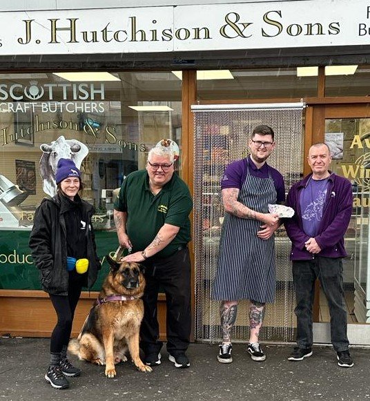 Photo of Karma with Jim at J Hutchison butchers with staff.